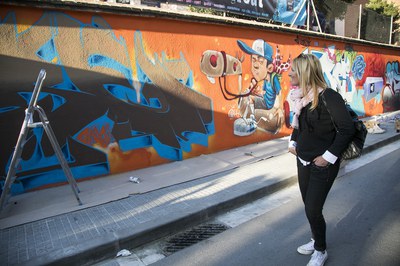 La alcaldesa, observando la evolución del graffiti que decora desde el sábado una de las paredes de la Torre Bassas (foto: Ayuntamiento – Lali Puig).