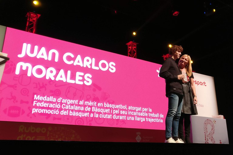 Reconocimiento a Juan Carlos Morales por su promoción del baloncesto en la ciudad. Recoge el Rubeo de Oro a su hijo Oriol