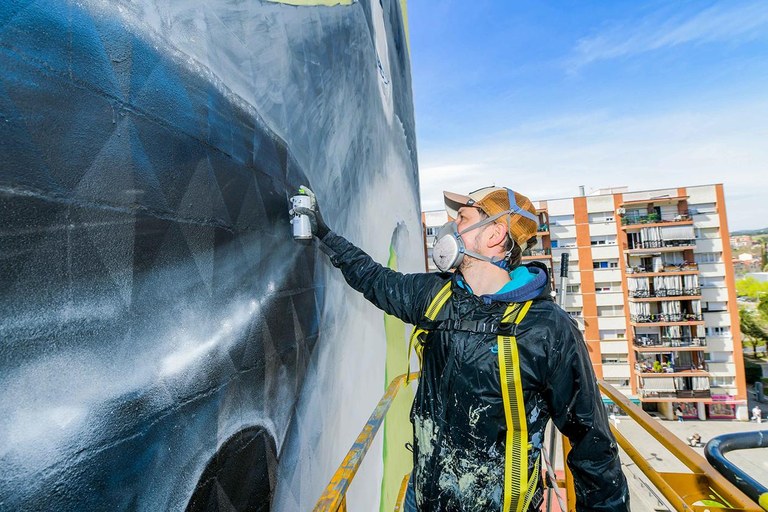 Urih en el proceso de pintar el mural